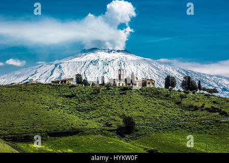 MESSINA, Sizilien: Ein Bild von einem Schnee bedeckt den Ätna, ergriffen von dem historischen Dorf Borgo Giuliano. Eine nukleare Pilz-wie Wolke Strahlen aus dem Ätna in Sizilien haben durch eine erstaunt lokale Mann gefangen genommen worden. Knisternden Flammen und riesige Rauchwolken sehen Pumpen aus der Spitze einer der aktivsten Vulkane der Welt.  Bilder zeigen, wie die Einwohner von Sizilien im Schatten dieses Monster-Berges Leben elf tausend Füße in der Höhe und der alte römische Gott des Feuers, Vulcan seiner Werkstatt gebaut. Landwirtschaft-Officer Fernando Famiani (51) aus San Teod Stockfoto