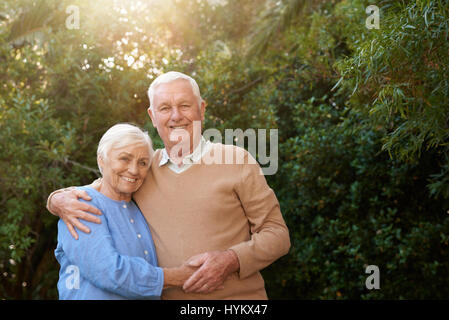 Entspannte Senioren zusammenstehen und lächelnd in ihrem Hinterhof Stockfoto