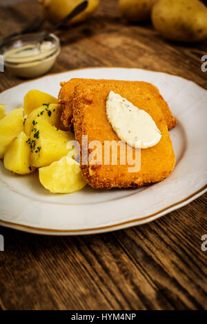 Gebackener Käse mit Kartoffeln und Dip auf Holztisch Stockfoto