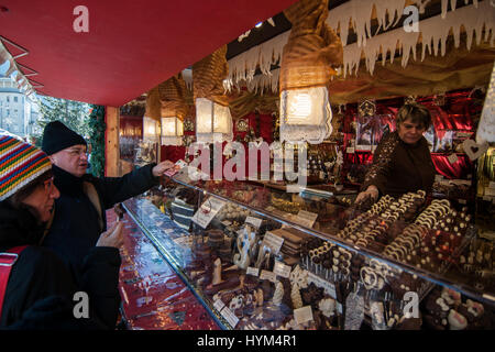 Aussteller in seinem Stand von typischen Produkten an den traditionellen Weihnachtsmärkten von Bozen in Italien. Stockfoto