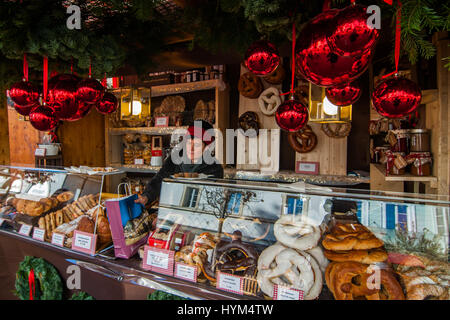 Aussteller in ihren Stand von typischen Produkten an den traditionellen Weihnachtsmärkten von Bozen in Italien. Stockfoto