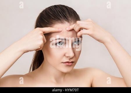 Junge Teenager-Mädchen drückt Pickel. Stockfoto