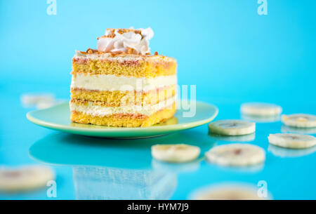 Bananen-Kuchen in einer Platte auf blauem Hintergrund Stockfoto