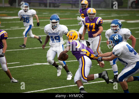 Highschool-Football-Spieler den Ball laufen und gehen mit Hemd anzugehen. Kretin Derham Hall (lila) VS Woodbury. St Paul Minnesota MN USA Stockfoto