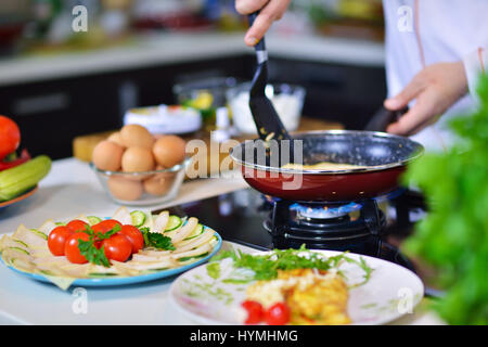 Mannes Hand hält ein Ei. Weißes Hühnerei. Koch beginnt Vorbereitung Omelette. Stockfoto