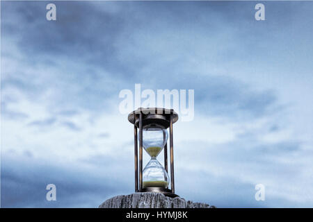 Sanduhr oder Sand Timer auf einem hölzernen Pfosten vor einem stimmungsvollen blauen Dämmerung Himmel. Stockfoto