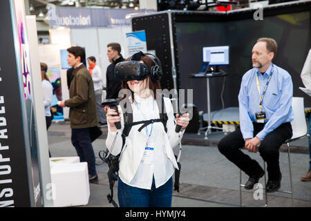 Mädchen spielen Videospiel in virtual-Reality-Kopfhörer und Handheld-Controller entwickelt von HTC Vive auf Messe Cebit 2017 in Hannover Messe, Deutschland Stockfoto