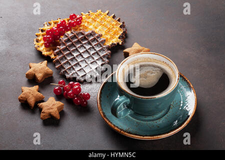 Kaffee mit Waffeln und Süßigkeiten am Steintisch Stockfoto