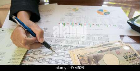 Unternehmen Frau Hand halten Sie Stift und auf Anweisung oder finanziellen Bericht und Japan Geld in Business-Konzept. Stockfoto