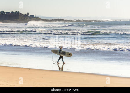 Frau mit Surf Board am Strand in Matosinhos Stadt, eingefaßt mit Porto, Teil der Subregion Grande Porto in Portugal Stockfoto