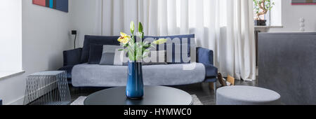 Blumen in Vase auf Couchtisch im stilvollen Wohnzimmer, Panorama Stockfoto