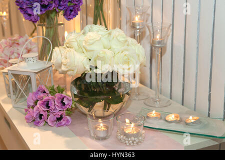 Tabelle mit weißen Rosen und Kerzen dekoriert Stockfoto