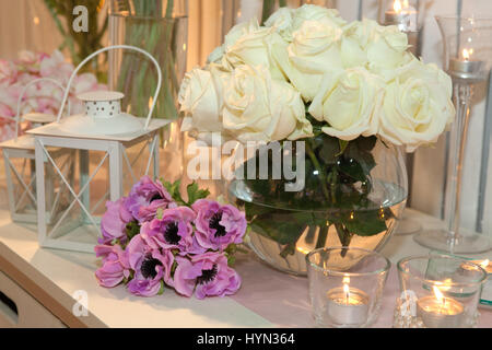 Tabelle mit weißen Rosen und Kerzen dekoriert Stockfoto