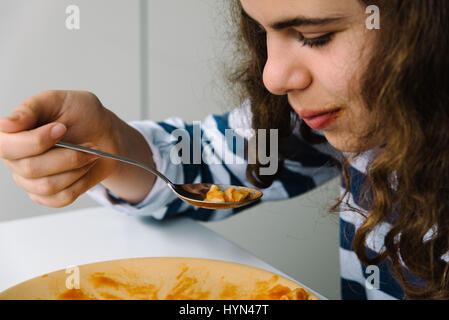 Mädchen, Pasta mit Löffel zu essen. Nahaufnahme Seitenansicht Stockfoto