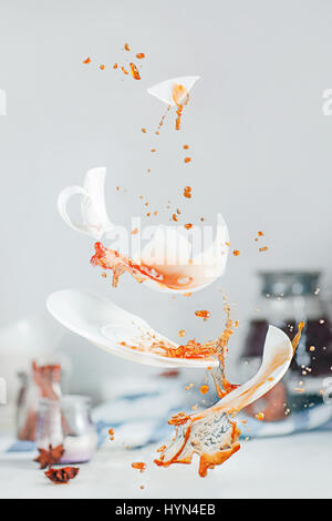 Fallenden Stücke einer gebrochenen Kaffeetasse mit Spritzer und Tropfen Stockfoto