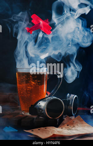 Wolke aus Dampf steigt aus einer Kaffeetasse mit einem fliegenden roten Flugzeug Stockfoto