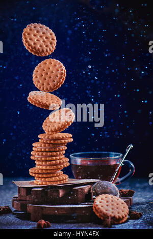 Dunkle Essen Foto mit einem Stack von fliegenden Cookies mit Puderzucker bestreut Stockfoto