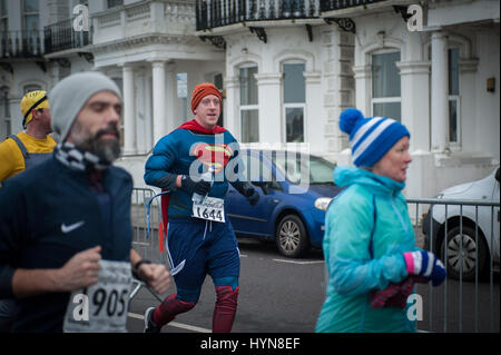 Ein Mann gekleidet in einem Superman-Superhelden-Kostüm laufen, während der Teilnahme an der Worthing Halbmarathon in Worthing, West Sussex, UK. Stockfoto