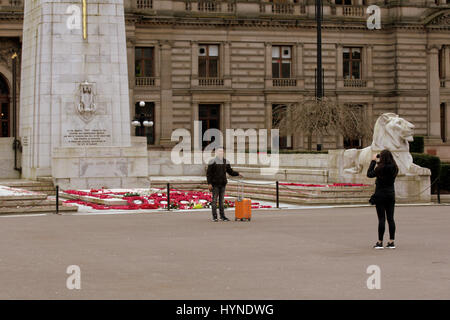 Asiatische Touristen fotografieren vor dem Kriegerdenkmal George Square, Glasgow Stockfoto