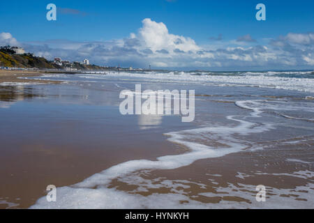 Bournemouth Beach zeigt Rand des Meeres mit der Flut kommen den Sand, ein Spiegelbild der Wolken und blauer Himmel auf dem nassen sandigen Ufer verlassen. Stockfoto