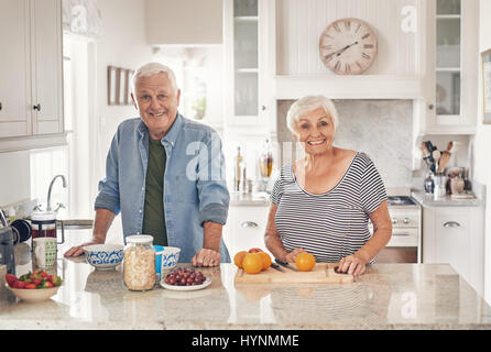 Lächelnden Senioren Vorbereitung ein gesundes Frühstück zusammen zu Hause Stockfoto