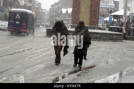 Srinagar, Kaschmir. 6. April 2017. Kashmiri Menschen gehen über ein Wasser angemeldet-Straße bei starkem Schneefall. Behörden bekannt, dass alle Schulen und Hochschulen in Kaschmir bis Montag angesichts des schlechten Wetters geschlossen würde. Bildnachweis: Sofi Suhail/Alamy Live-Nachrichten Stockfoto