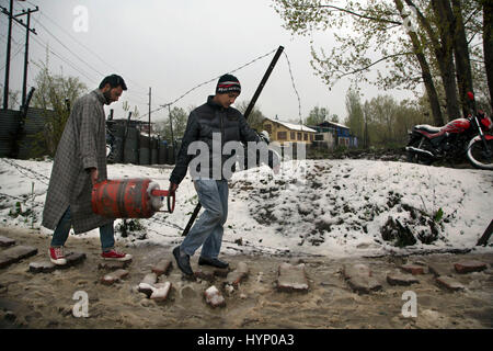 Srinagar, Kaschmir Indien kontrollierten. 6. April 2017. Kashmiri Männer tragen Kochen Gasflasche nach einem Schneefall in Srinagar, Sommer in der Hauptstadt von Indien kontrollierten Kaschmir, 6. April 2017. Dauerregen und Schneefall in Indien kontrollierten Kaschmir ausgelöst Donnerstag Angst vor Überschwemmungen unter den Bewohnern. Bildnachweis: Javed Dar/Xinhua/Alamy Live-Nachrichten Stockfoto