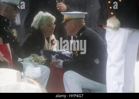 Arlington, Vereinigte Staaten von Amerika. 6. April 2017. Kommandant des Marine Corps General Robert Neller, Recht, stellt die Flagge Anne Glenn, Witwe von John Glenn, während die Graveside Service in Abschnitt 35 des Arlington National Cemetery 6. April 2017 in Arlington, Virginia. Glenn, der erste amerikanische Astronaut, die Erde zu umkreisen und später ein Senator der Vereinigten Staaten, starb im Alter von 95 Jahren am 8. Dezember 2016. Bildnachweis: Planetpix/Alamy Live-Nachrichten Stockfoto