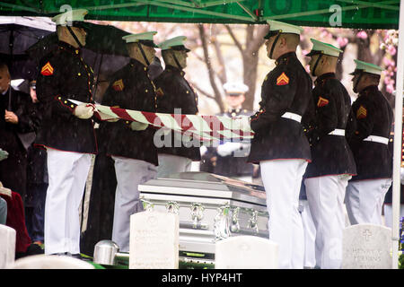 Arlington, Vereinigte Staaten von Amerika. 6. April 2017. Marine Corp Ehrengarde halten die Flagge über dem Sarg von John Glenn, wie er bestattet ist auf dem Arlington National Cemetery 6. April 2017 in Arlington, Virginia. Glenn, der erste amerikanische Astronaut, die Erde zu umkreisen und später ein Senator der Vereinigten Staaten, starb im Alter von 95 Jahren am 8. Dezember 2016. Bildnachweis: Planetpix/Alamy Live-Nachrichten Stockfoto