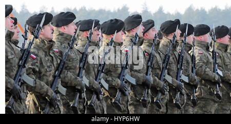 Polnische Soldaten marschieren in Formation und singen die Nationalhymne während einer Willkommenszeremonie für US-Soldaten im Bereich von Karlikie 30. Januar 2017 in Zagan, Polen. Stockfoto