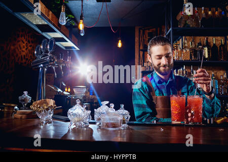 Der Barkeeper lacht machen einen Cocktail an der bar Stockfoto