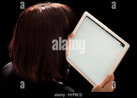 Blick auf das iPad Pro Frau hielt in der hand vor schwarzem Hintergrund Stockfoto