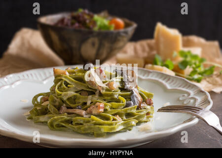 Grüne Spinat Pasta Tagliatelle mit braunen Shimeji Pilze, Speck und Parmesan-Käse Stockfoto