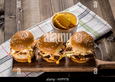 Hausgemachte Mini-Rindfleisch-Burger mit Krautsalat Salat auf kleinen Holzbrett. Grill-Fleisch-Sandwiches auf rustikalen Tisch. Stockfoto