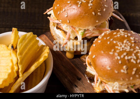 Hausgemachte Mini-Rindfleisch-Burger mit Krautsalat Salat auf kleinen Holzbrett. Grill-Fleisch-Sandwiches auf rustikalen Tisch. Stockfoto