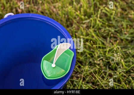 Ein kleines Spielzeug aus Plastik Segelboot in einen Eimer mit Wasser schweben. Stockfoto