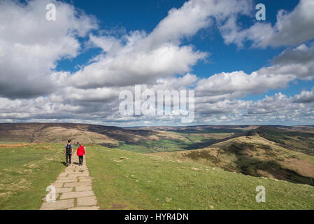 Junges Paar zu Fuß entlang des Grates von Mam Tor im Peak District an einem sonnigen Frühlingstag. Stockfoto