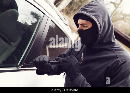 Kfz-Diebstahl - Dieb versucht, in das Fahrzeug zu brechen Stockfoto