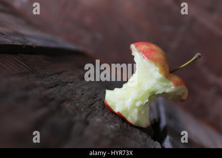 angebissene Apfel auf einem hölzernen Hintergrund Stockfoto