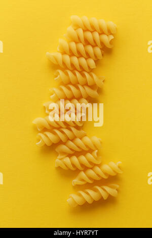 Fusilli Nudeln Spiralen auf gelbem Hintergrund Stockfoto