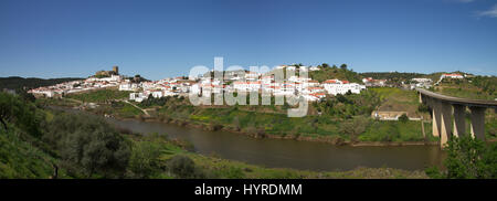 Panorama der Stadt Mertola und Brücke gesehen von der anderen Seite des Flusses Guadiana. Alentejo, Portugal. Stockfoto