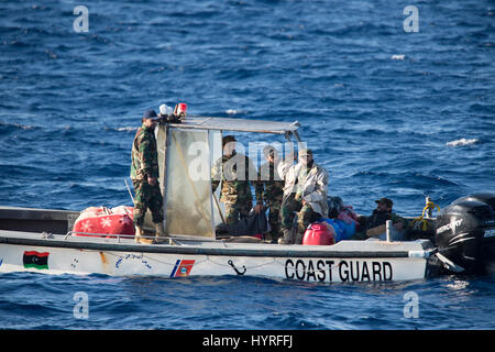 Ein kleines Boot mit 4 Personen, die sich selbst libyschen Küstenwache ein Rubberboat mit Migranten und beobachten und dokumentieren die SAR-Operation folgte Stockfoto