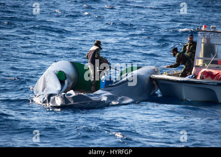 Ein kleines Boot mit 4 Personen, die sich selbst libyschen Küstenwache ein Rubberboat mit Migranten und beobachten und dokumentieren die SAR-Operation folgte Stockfoto