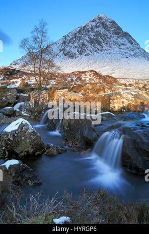 Blick auf den Wasserfall vor dem Schnee bedeckt Buachaille Etive Mor in Glencoe-Schottland Stockfoto