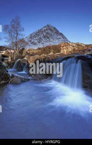 Blick auf den Wasserfall vor dem Schnee bedeckt Buachaille Etive Mor in Glencoe-Schottland Stockfoto