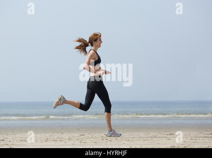 Eine Frau Läufer Übung am Strand genießen Stockfoto