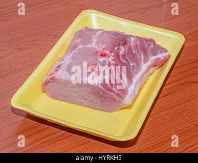 Rohes Schweinefleisch auf ein gelbes Schild, Nahaufnahme, hölzernen Hintergrund. Stockfoto