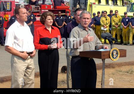 Kaliforniens Gouverneur Arnold Schwarzenegger und Kalifornien Senatorin Dianne Feinstein zusehen, wie US-Präsident George W. Bush während eines Besuchs ein Lauffeuer am Kit Carson Park 25. Oktober 2007 in Escondido, Kalifornien spricht. Stockfoto