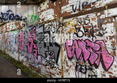 Eine Wand eines verlassenen Gebäudes mit lebendigen Straße Graffiti bedeckt. Stockfoto