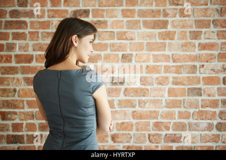 Rückansicht des eleganten Frau an der Wand Stockfoto